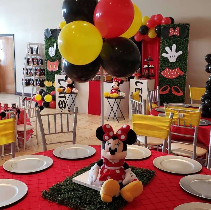 a mickey mouse themed birthday party with balloons and tableware set up for the event