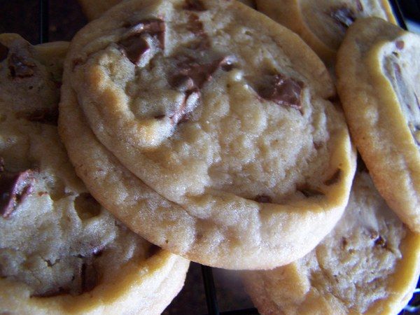 chocolate chip cookies stacked on top of each other in front of a cooling grate