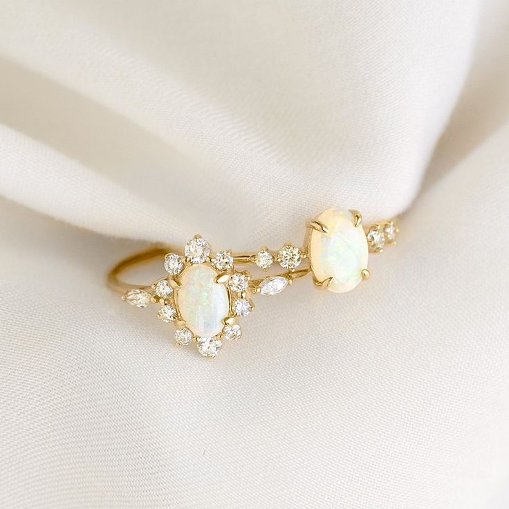 an opal and diamond ring on a white cloth