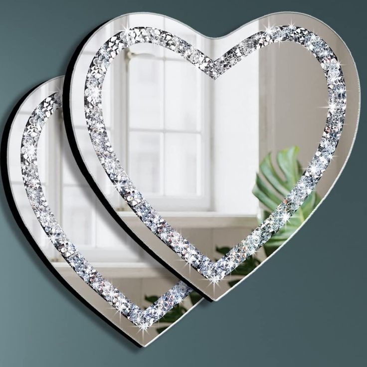 two heart shaped mirrors are shown in front of a window