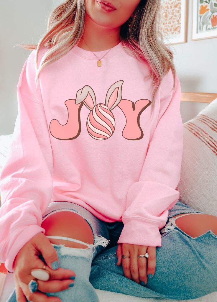 Comfy and super cute, this fun Easter Sweatshirt features a cute retro Joy Easter Bunny graphic on the front and a soft cozy interior. Fit is true to size, for oversized fit, size up 1-2 sizes. Available in super cute colors such as Light Pink, Light Blue, Sand and White. Perfect for Easter season. Free Shipping USA. Be Cozy. Joy Easter Sweatshirt  50% Cotton 50% Poly Medium-heavy fabric  Loose fit crewneck Machine wash cold inside out hang to dry True to size fit, for oversized fit size up Available in Sand, White, Light Pink & Light Blue Free Shipping USA Be Cozy Mom Christmas Shirt, Mama Bear Sweatshirt, Mom Clothing, Coffee Christmas, Christmas Retro, Pink Coffee, Face Graphic, Retro Valentines, West Highland Terrier