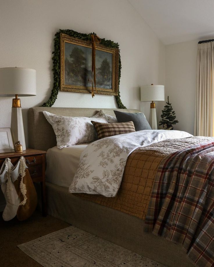 a bed with plaid blankets and pillows in a bedroom next to a christmas wreath on the wall