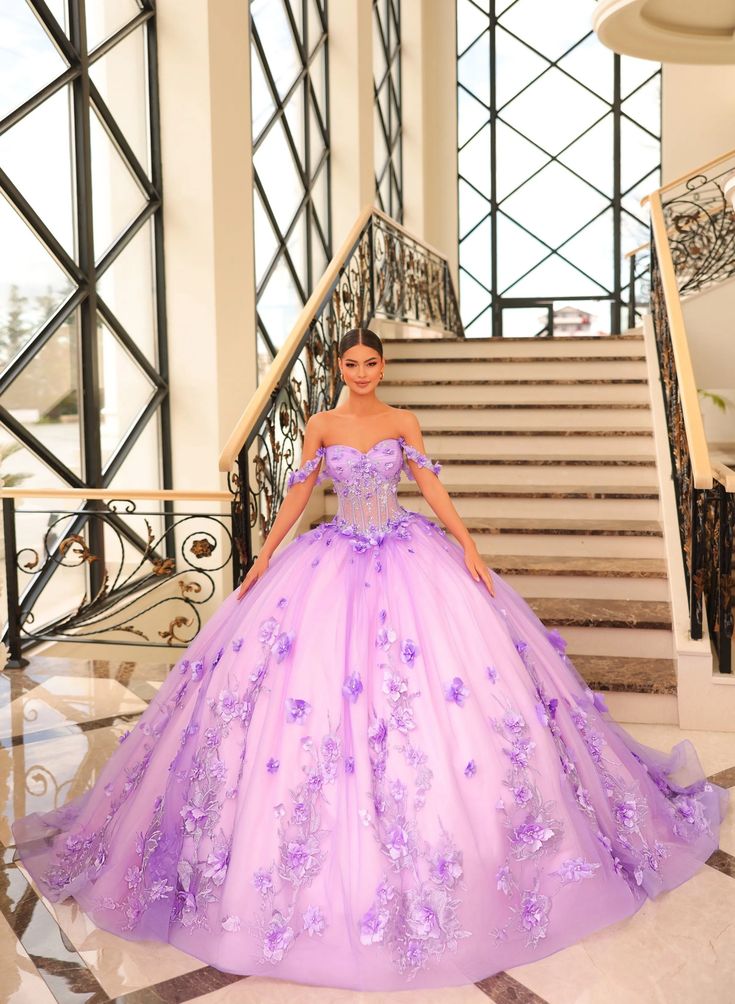 a woman in a purple ball gown standing on stairs