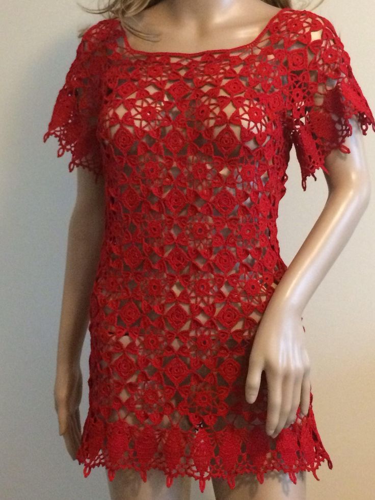 a mannequin wearing a red crochet dress with short sleeves and an open back