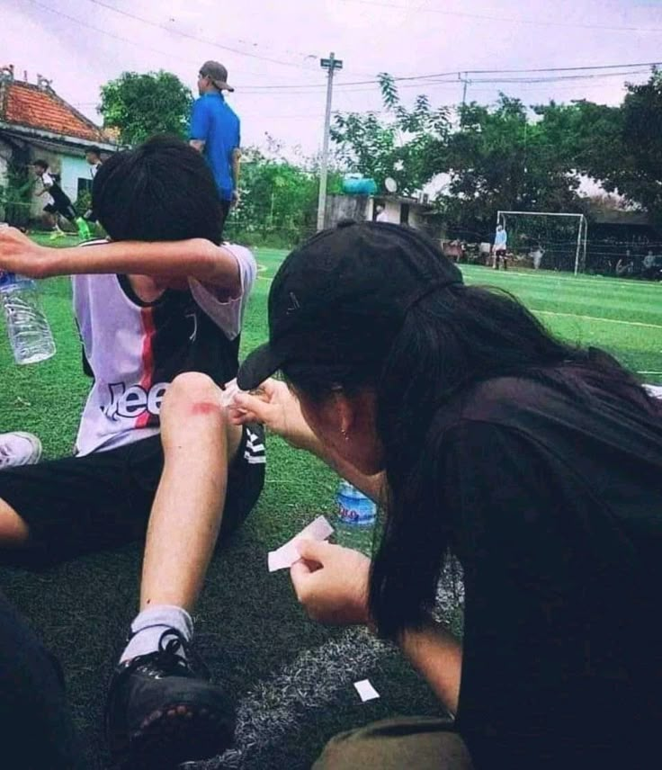 a group of young people sitting on top of a soccer field