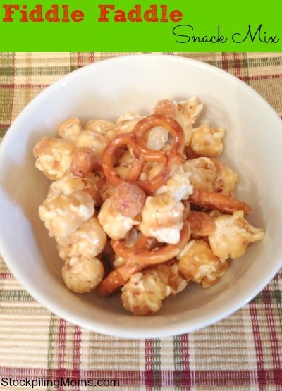 a white bowl filled with snack mix on top of a checkered tablecloth covered table