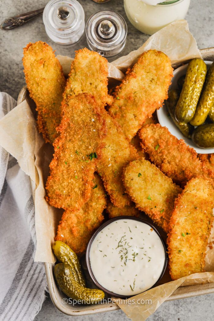 a basket filled with fried pickles and dipping sauce