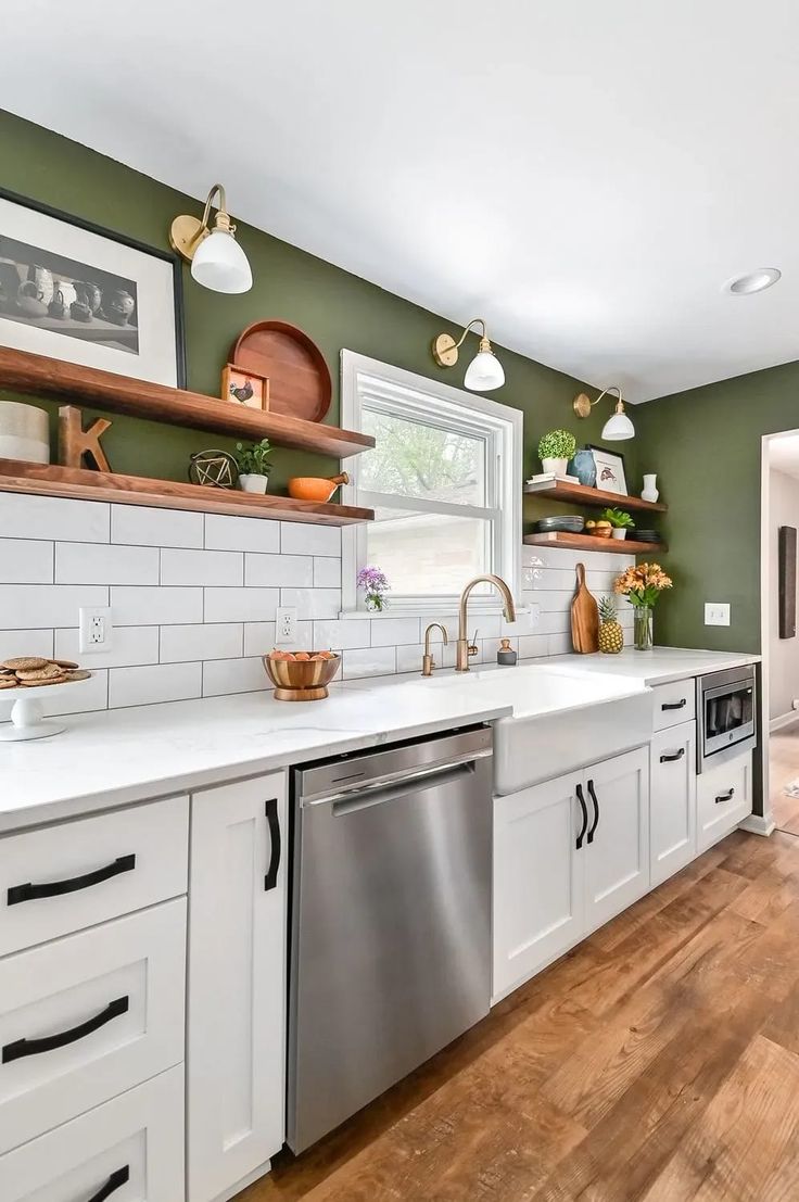 a kitchen with green walls and white cabinets