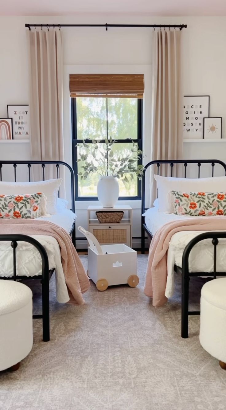 a bedroom with two twin beds and an ottoman in front of the window, along with a small white stool