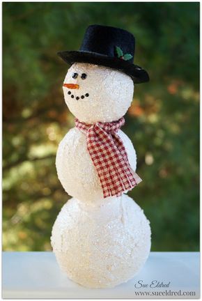 a snowman made out of cotton balls with a top hat and scarf on it