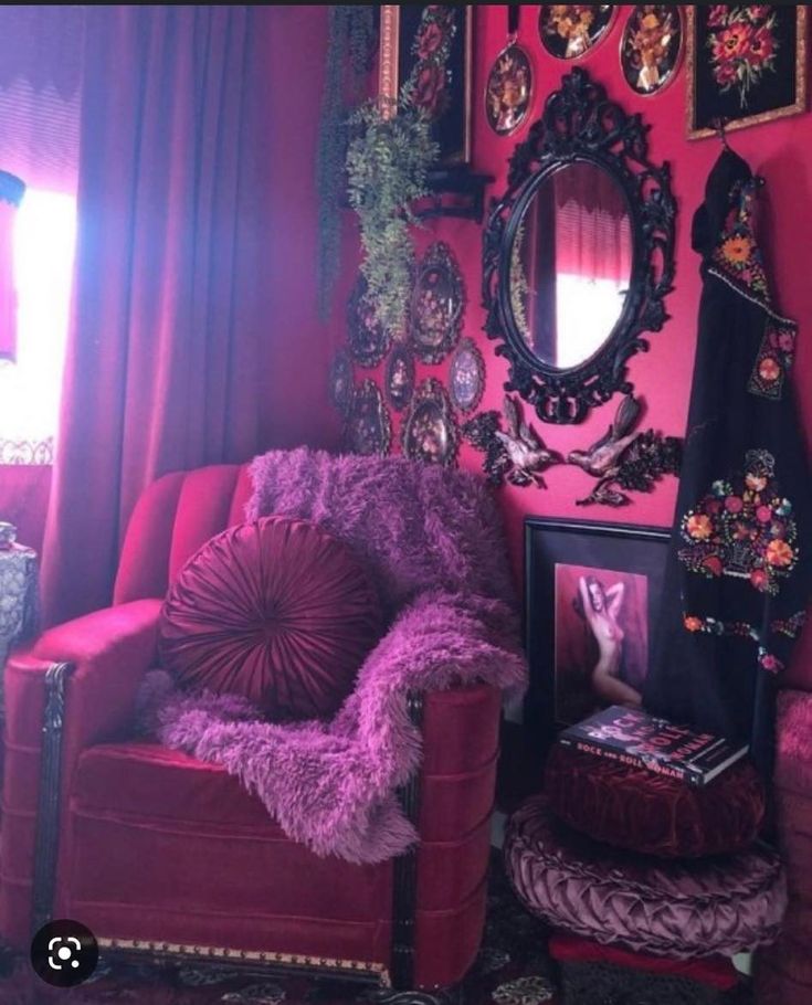 a living room with pink walls and pictures on the wall, including a red chair