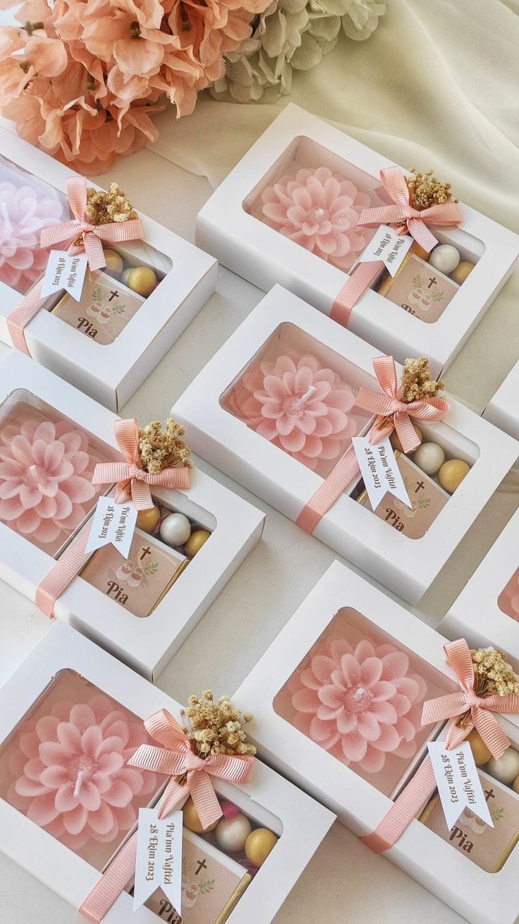 six boxes with pink flowers and chocolates in them