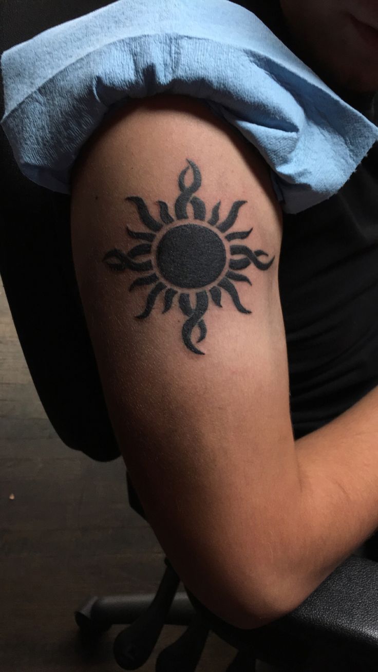 a person with a sun tattoo on their arm