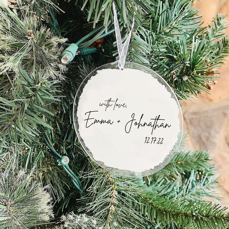 a personalized ornament hanging from a christmas tree