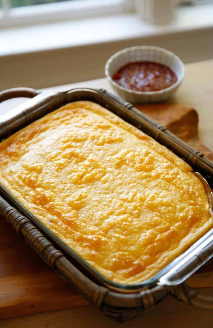 a casserole in a pan on a wooden table next to some condiments