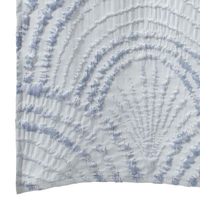 a white and blue pillow with an intricate design on the front, in shades of light blue