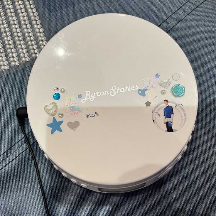 a white compact case with stickers on it sitting on a blue carpeted floor