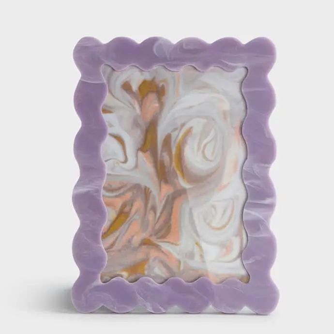 a purple and white square shaped object with swirls on it's sides, in front of a gray background