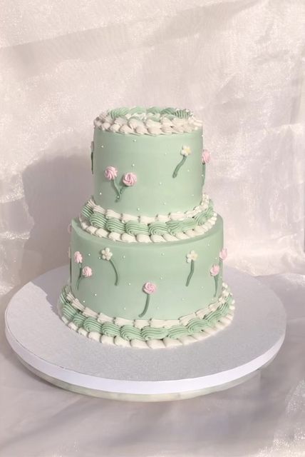 a three tiered cake sitting on top of a white platter with pink flowers