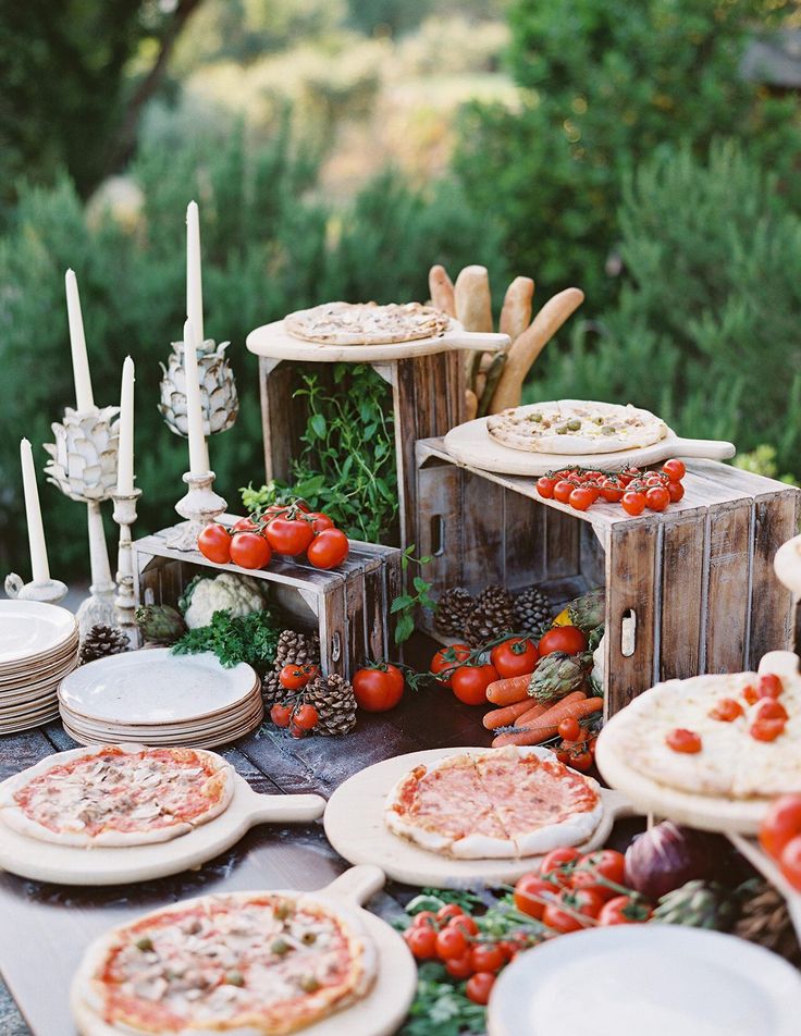 a table topped with pizzas and other food