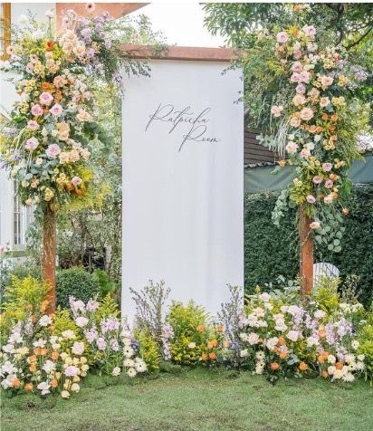 an outdoor ceremony with flowers and greenery