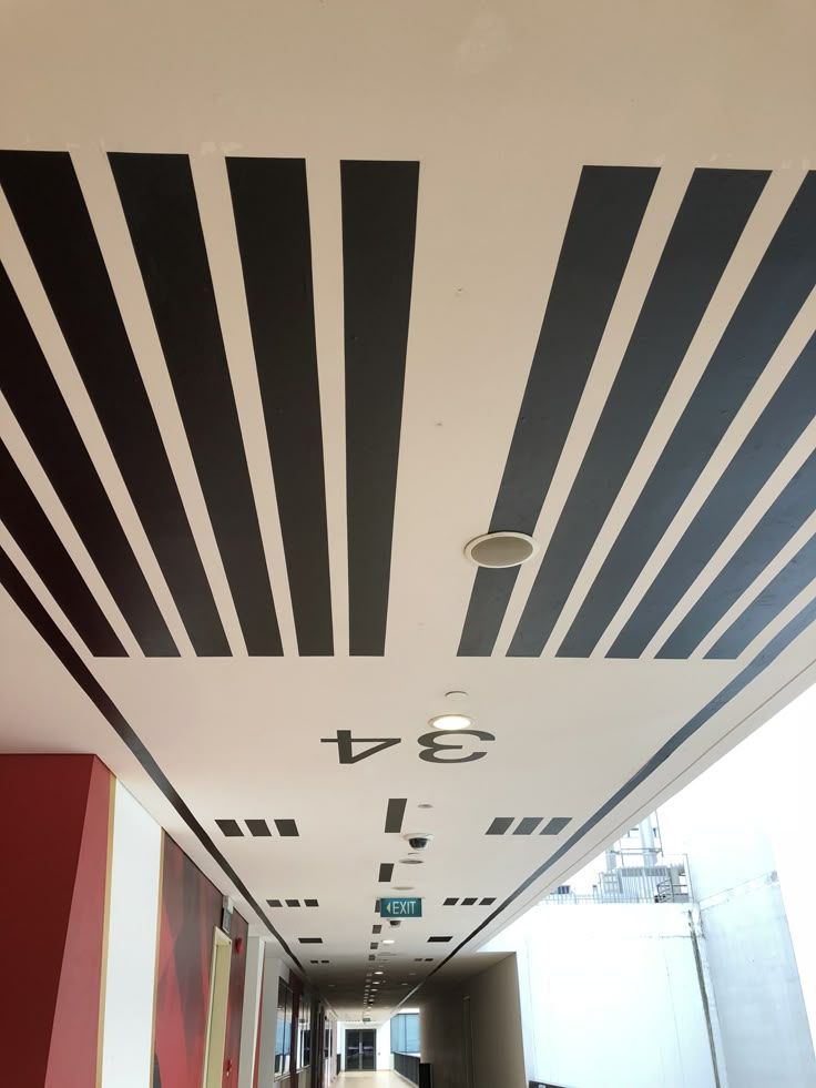 an empty hallway with black and white lines painted on the ceiling