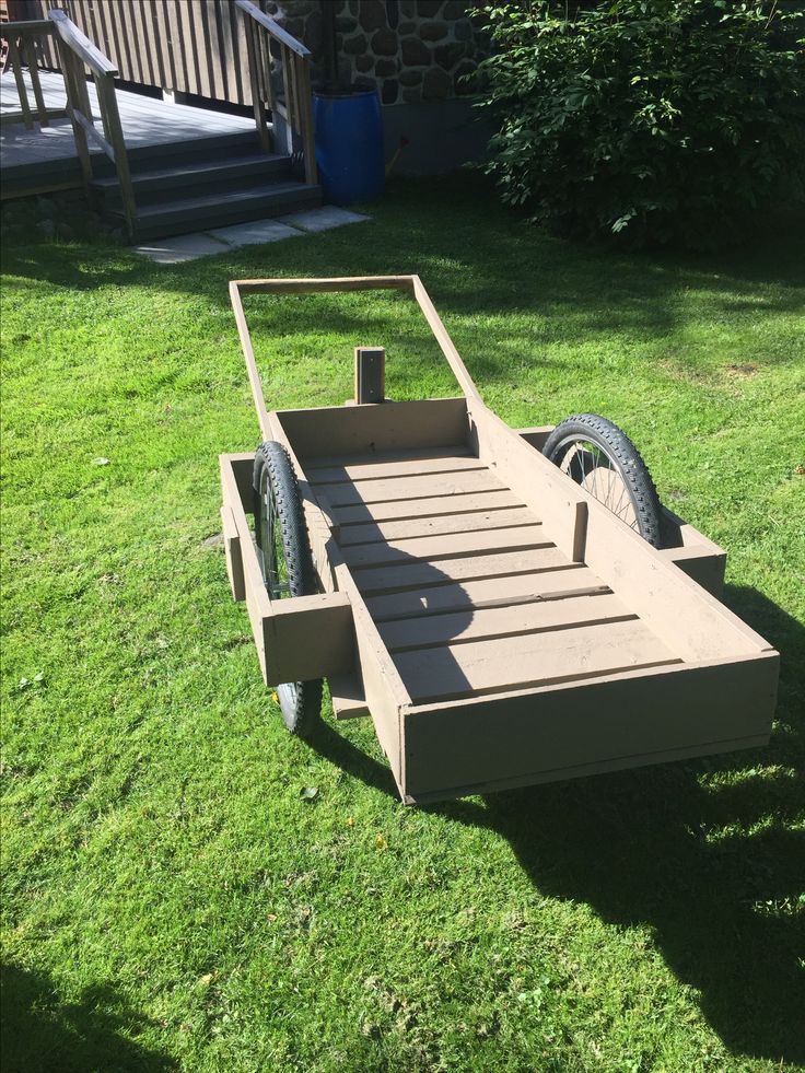 a wooden trailer sitting on top of green grass