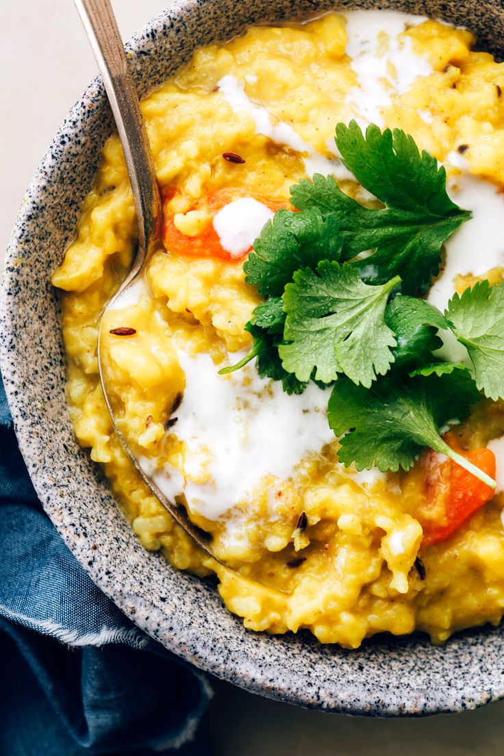 a bowl filled with rice and garnished with cilantro, parsley and sour cream