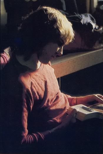 a young boy sitting on the floor reading a book