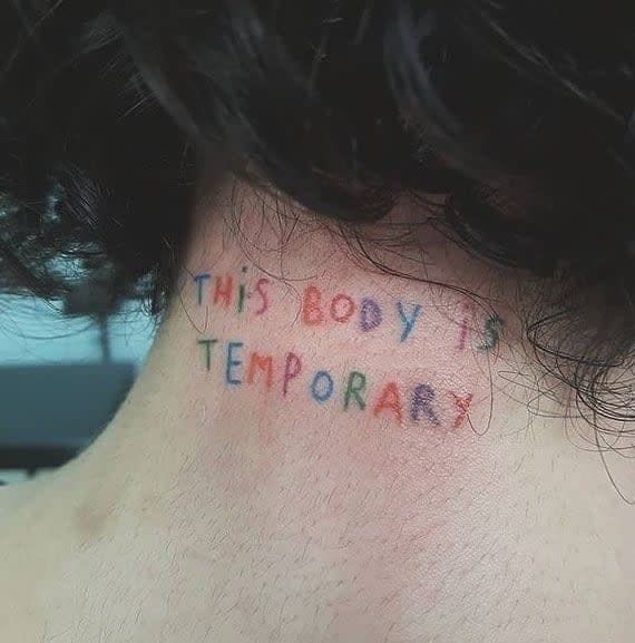 the back of a woman's neck with writing on it that says, this boy is temporary