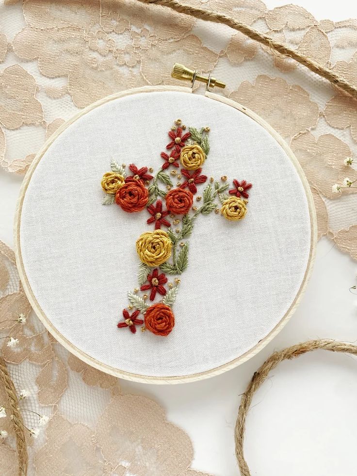 an embroidered cross with flowers on it