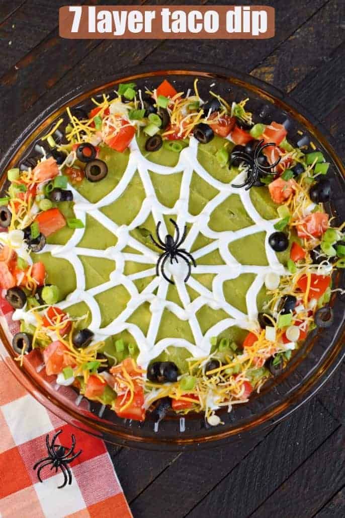 a halloween spider web cake with black olives, tomatoes and cheese on top for decoration