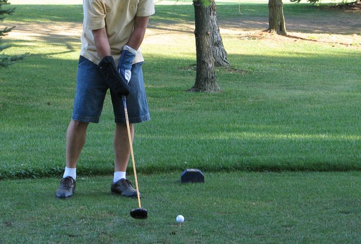 a man is playing golf in the grass with his club and ball on the ground