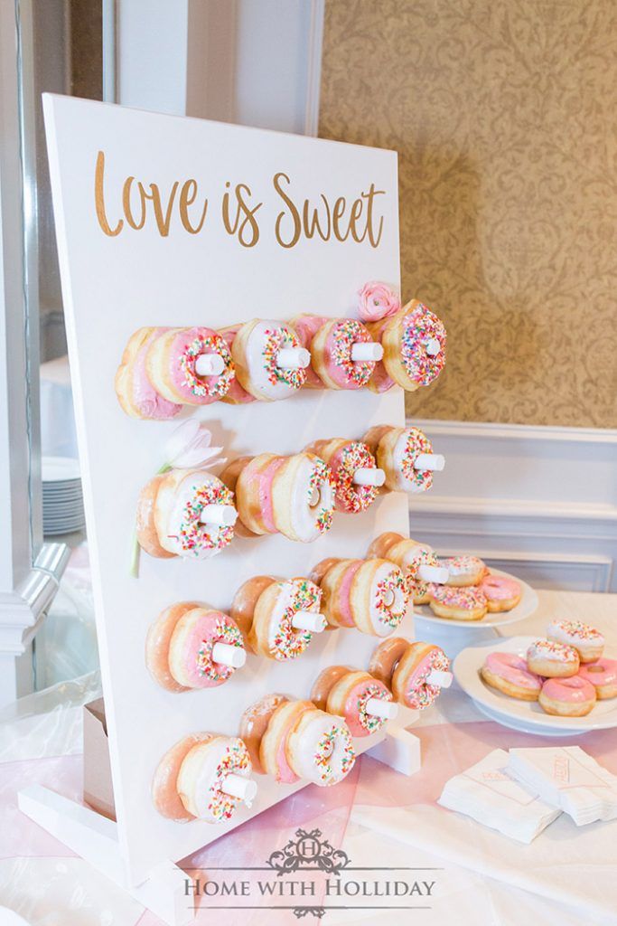 there is a sign that says love is sweet and some donuts are on the table