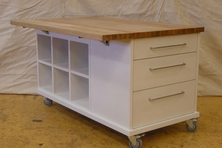 a kitchen island with drawers and wheels on it