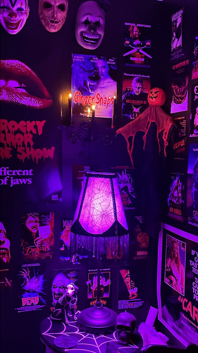 a room filled with halloween decorations and creepy masks on the wall above a table topped with a lamp