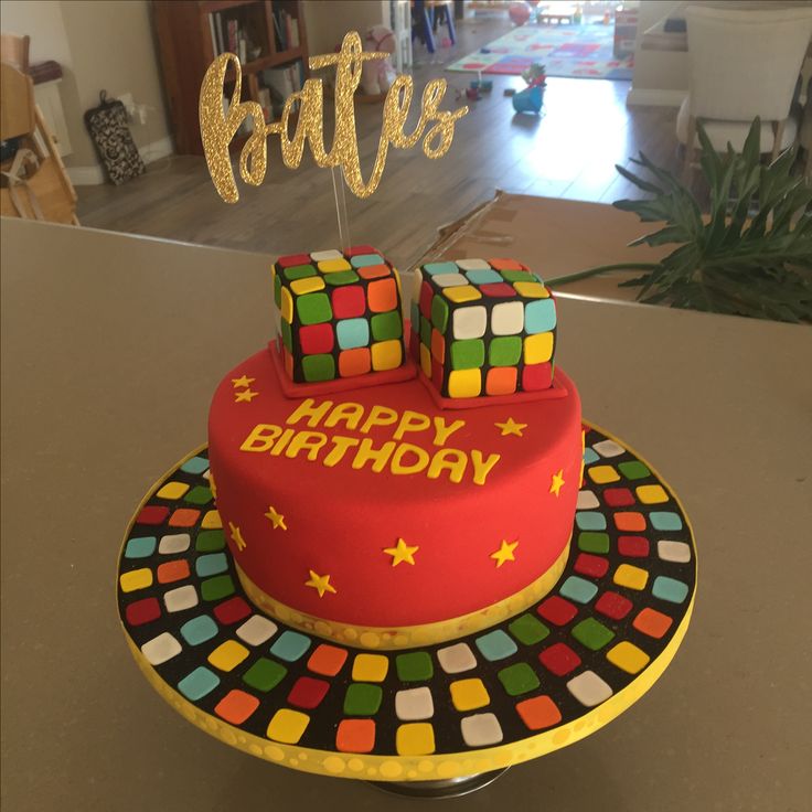 a birthday cake decorated with rubik cubes