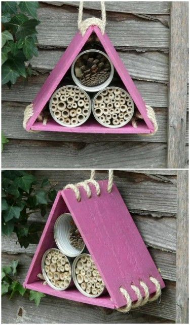 two bird feeders hanging from the side of a wooden fence, one with holes in it