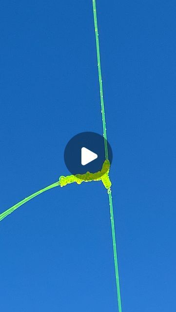 a green pole with a white arrow on it and a blue sky in the background