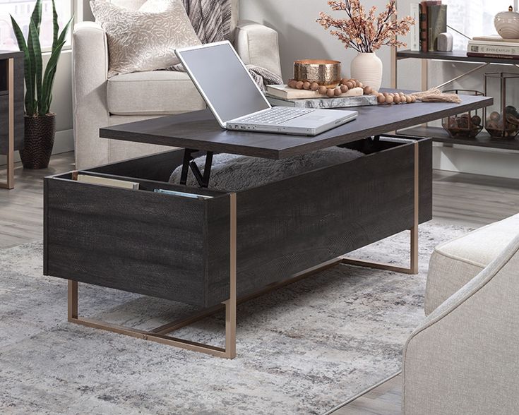 a coffee table with a laptop on it in a living room area next to a couch