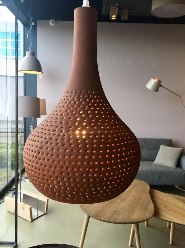 a large brown vase sitting on top of a wooden table next to a gray couch