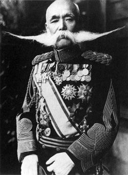 an old black and white photo of a man with a mustache wearing a uniform that has flowers on it