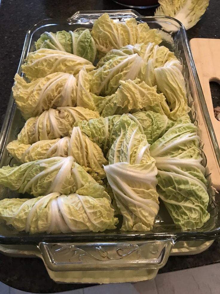 cabbage in a glass baking dish next to a cutting board