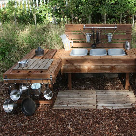 an outdoor kitchen made out of wooden pallets and steel pans on top of it