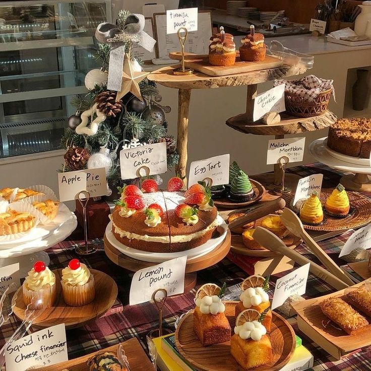 a table topped with lots of different types of cakes and pastries on wooden trays