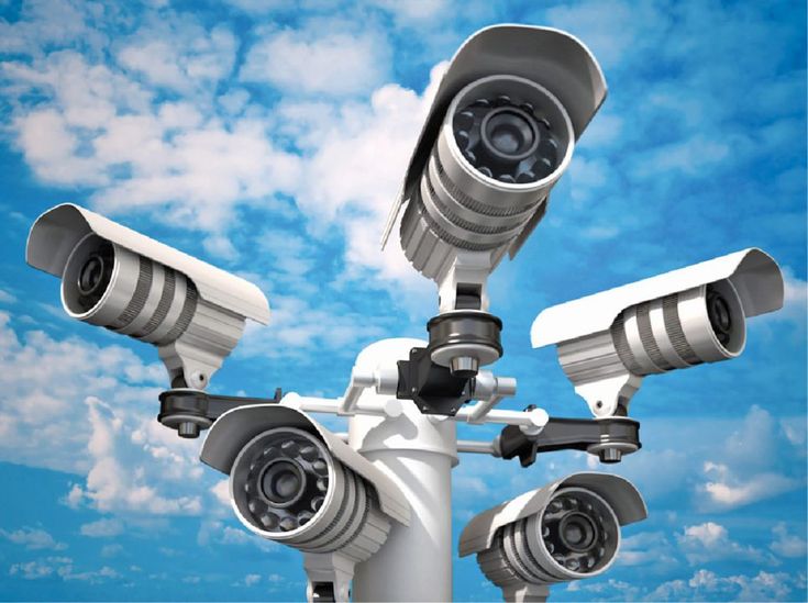 two cameras on top of each other in front of a blue sky with white clouds