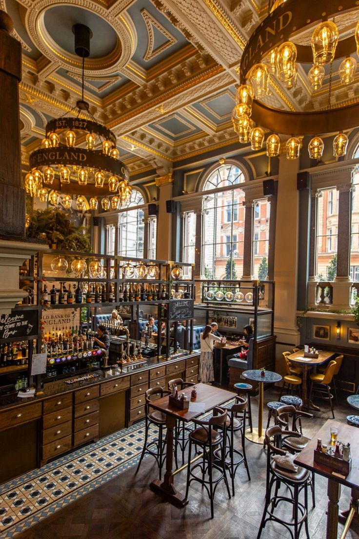 the interior of a restaurant with many tables and chairs, chandeliers hanging from the ceiling