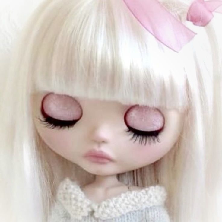 a doll with long blonde hair and pink eyes