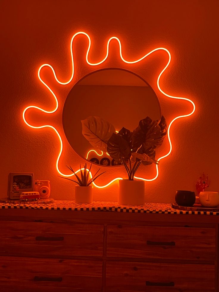 a mirror that is sitting on top of a dresser next to a potted plant