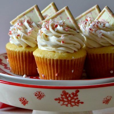 cupcakes with white chocolate frosting and sprinkles on a plate